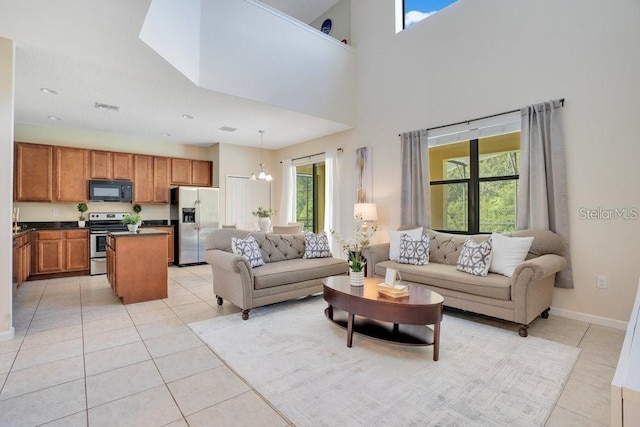 living room with light tile patterned flooring, a high ceiling, and a chandelier