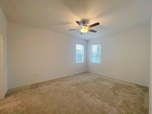 spare room with light carpet, a textured ceiling, and ceiling fan