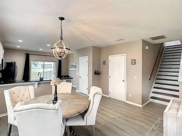 dining room with a chandelier and light hardwood / wood-style flooring