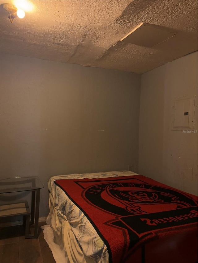 bedroom featuring a textured ceiling and electric panel