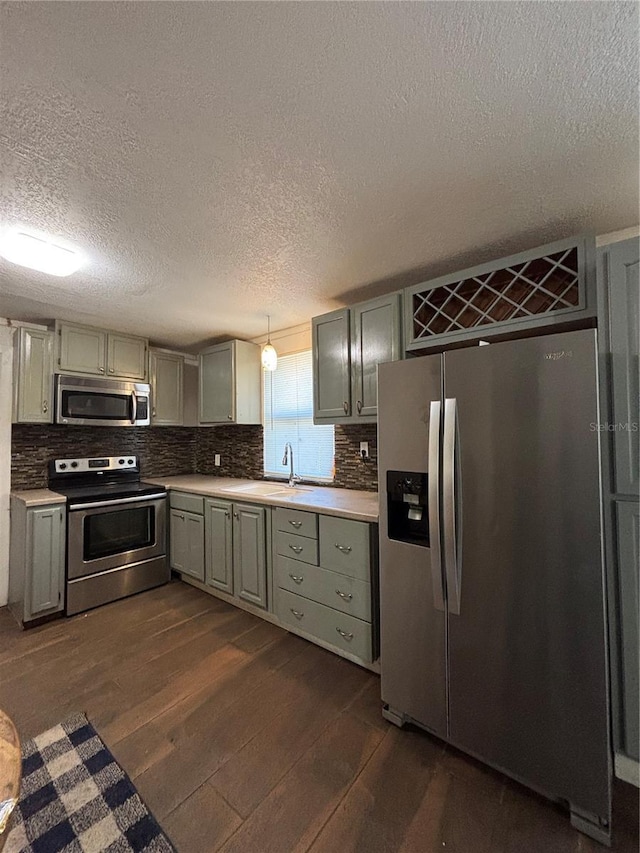 kitchen featuring hanging light fixtures, appliances with stainless steel finishes, dark hardwood / wood-style flooring, and gray cabinetry