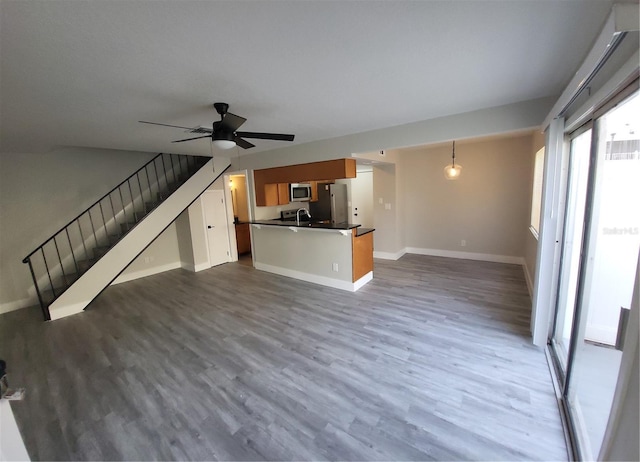 unfurnished living room with ceiling fan and dark hardwood / wood-style floors