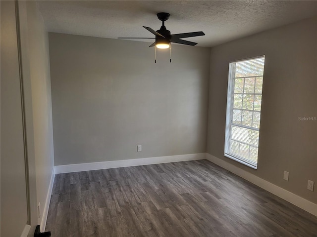 empty room with a textured ceiling, dark hardwood / wood-style flooring, and ceiling fan