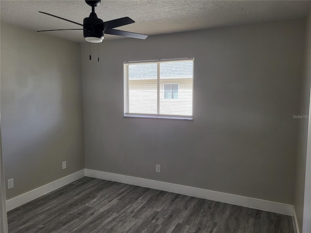 empty room featuring ceiling fan, a textured ceiling, and dark wood-type flooring