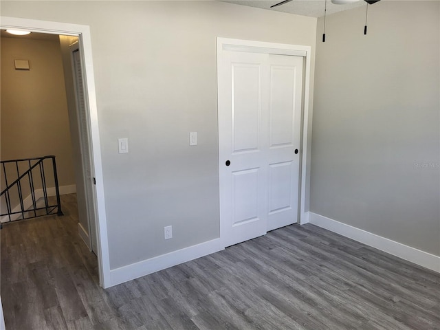 unfurnished bedroom with a closet and dark hardwood / wood-style floors