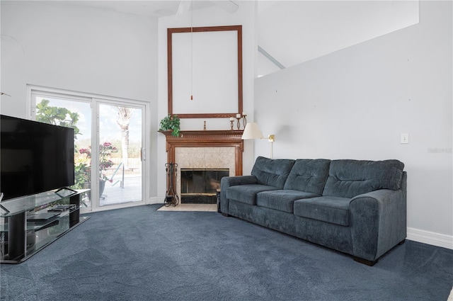 living room featuring carpet floors, a fireplace, a towering ceiling, and baseboards