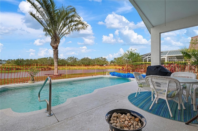 view of pool featuring a fenced in pool, a patio, grilling area, fence, and a fire pit