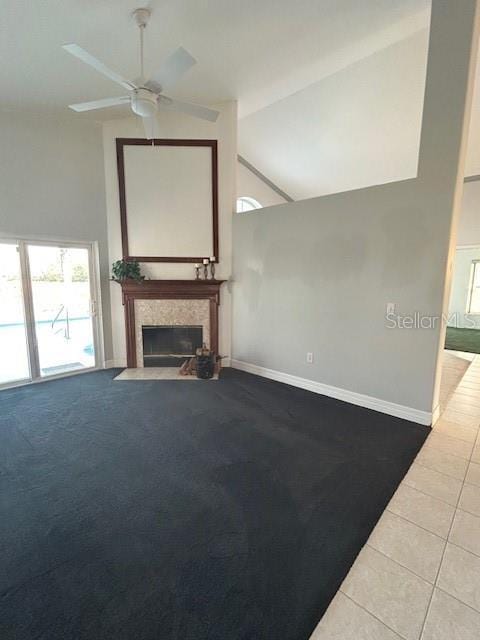 unfurnished living room with a fireplace, tile patterned floors, a ceiling fan, and baseboards