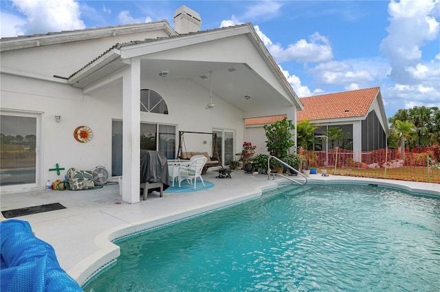 rear view of house with a patio, fence, a fenced in pool, and stucco siding