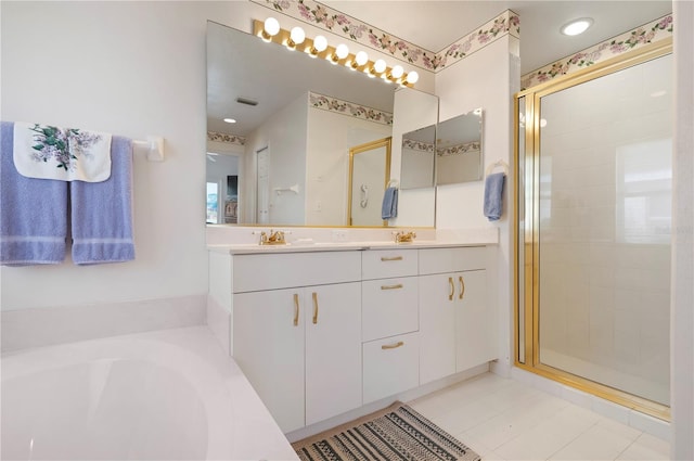 bathroom with double vanity, a stall shower, a garden tub, and a sink