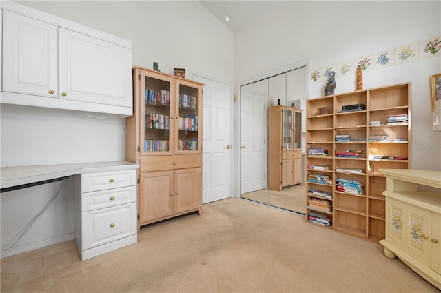 home office with light carpet and vaulted ceiling