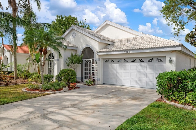 mediterranean / spanish house with a garage, concrete driveway, and stucco siding