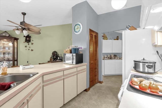 kitchen with white cabinetry, sink, ceiling fan, and stove