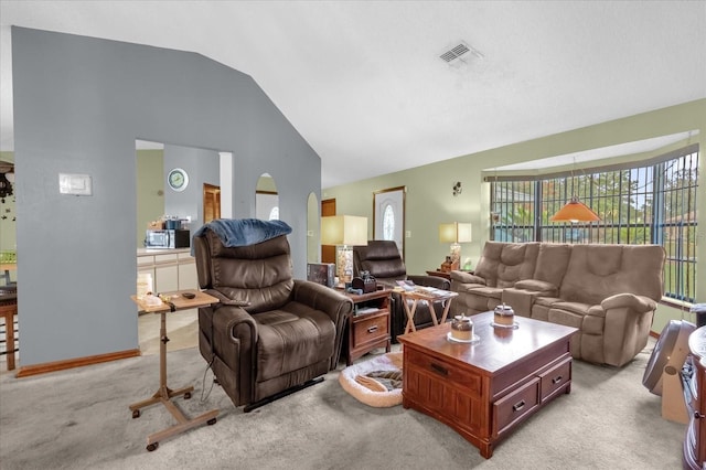 living room featuring plenty of natural light, light colored carpet, and lofted ceiling