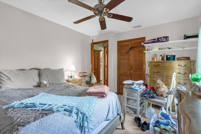 bedroom with ceiling fan, light colored carpet, and a closet