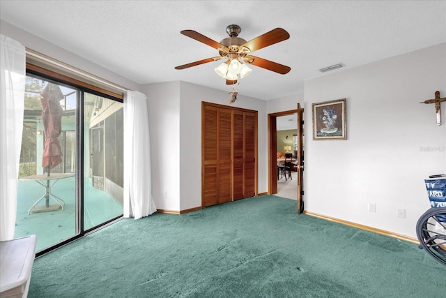 interior space with carpet flooring, access to exterior, ceiling fan, and a closet