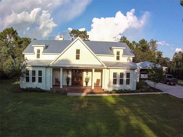 modern inspired farmhouse featuring covered porch and a front yard