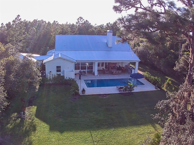 rear view of property featuring a lawn, an outdoor hangout area, and a patio