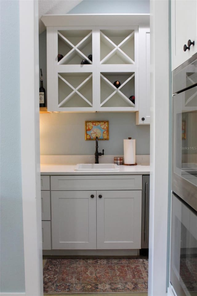 bar with sink and white cabinets