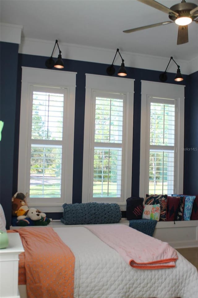 bedroom with ceiling fan and ornamental molding