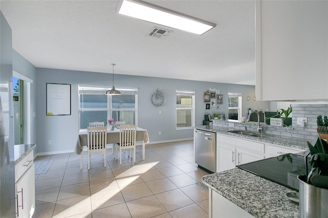 kitchen featuring pendant lighting, white cabinets, sink, stainless steel dishwasher, and light tile patterned flooring