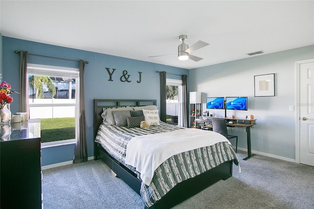 carpeted bedroom featuring multiple windows and ceiling fan