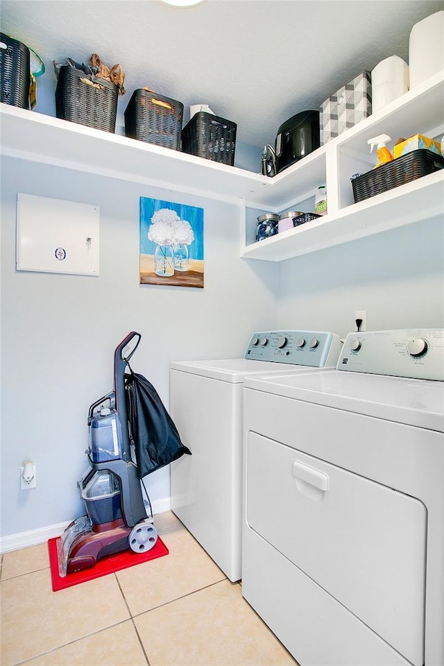 laundry room with light tile patterned floors and washing machine and clothes dryer