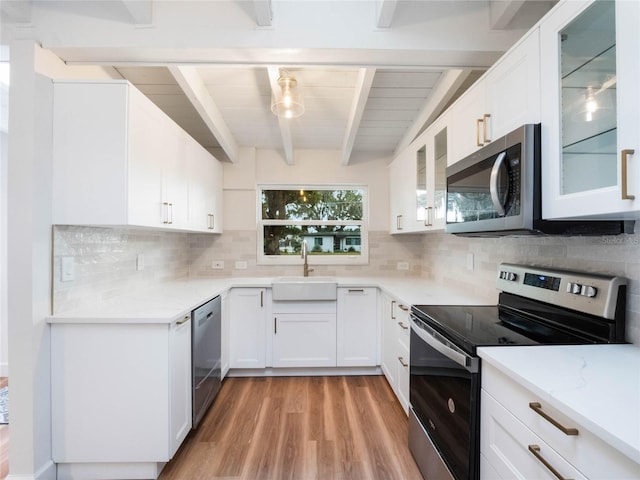 kitchen featuring white cabinets, sink, light hardwood / wood-style flooring, decorative backsplash, and stainless steel appliances