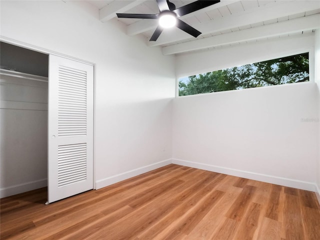 unfurnished bedroom featuring ceiling fan, beamed ceiling, wood-type flooring, and wooden ceiling