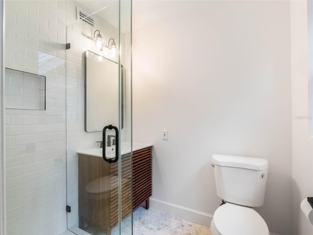 bathroom featuring tile patterned flooring, toilet, and a shower with shower door