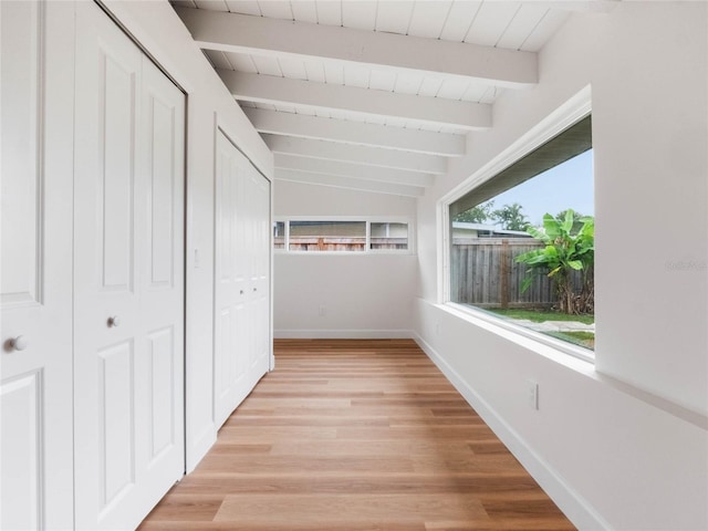 hall with vaulted ceiling with beams and light hardwood / wood-style floors