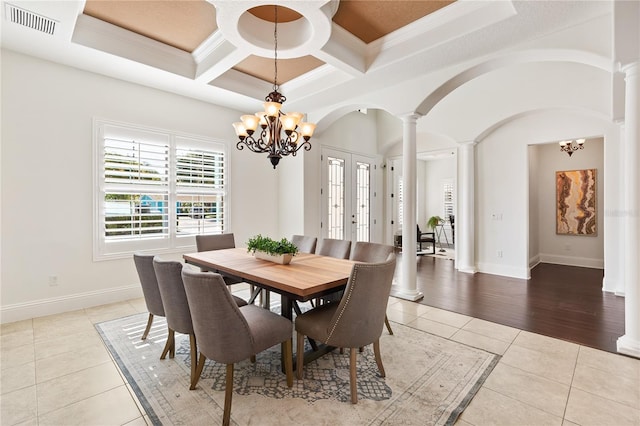 tiled dining room with a chandelier, french doors, ornate columns, and coffered ceiling