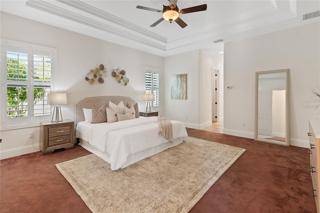 bedroom with a raised ceiling, multiple windows, ceiling fan, and dark colored carpet