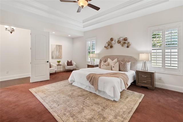 bedroom with ceiling fan with notable chandelier, a raised ceiling, multiple windows, and crown molding