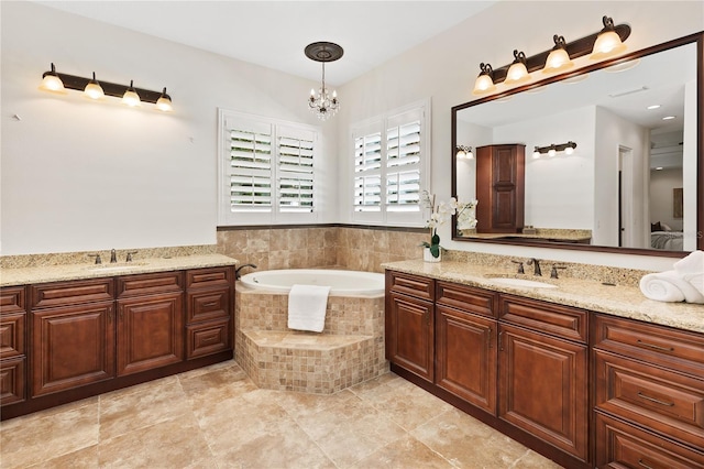 bathroom featuring vanity, a relaxing tiled tub, and a chandelier