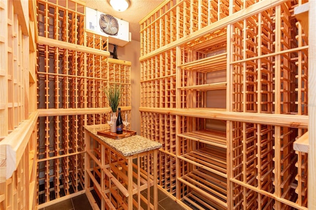 wine area with tile patterned floors and a textured ceiling