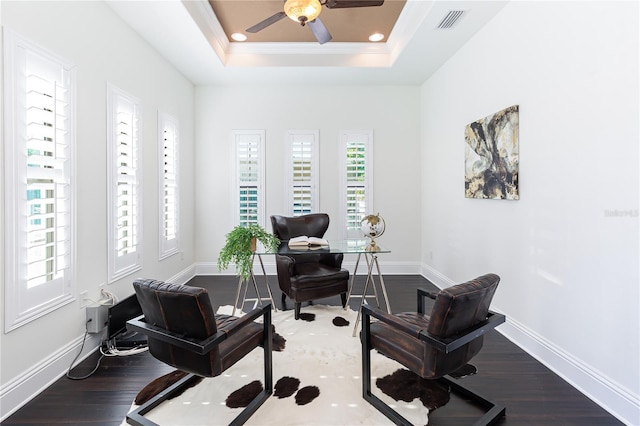 office space with ceiling fan, crown molding, dark wood-type flooring, and a tray ceiling