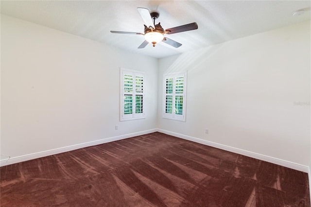 carpeted spare room featuring ceiling fan