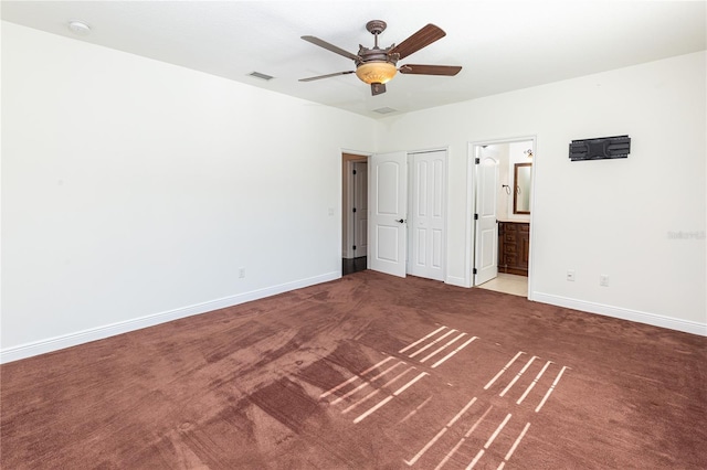 unfurnished bedroom featuring carpet flooring, ensuite bathroom, and ceiling fan