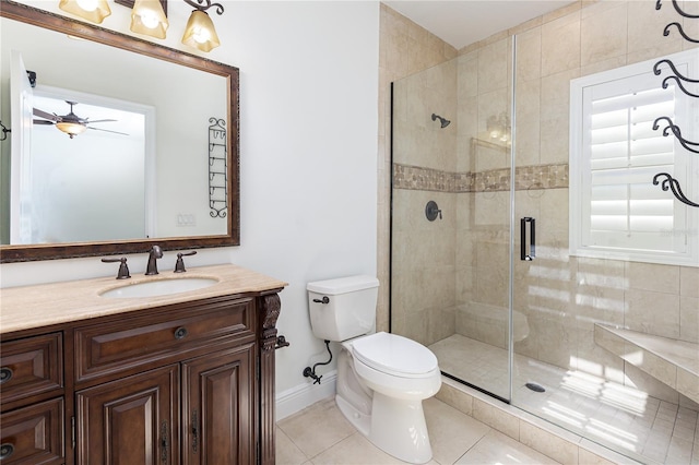 bathroom featuring vanity, a shower with door, tile patterned floors, ceiling fan, and toilet