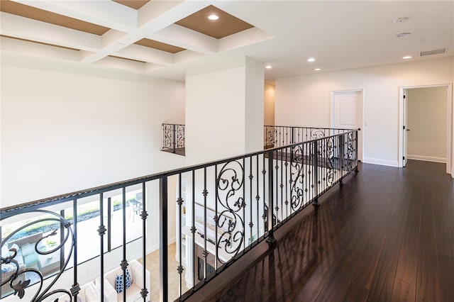 hall featuring beam ceiling, dark wood-type flooring, and coffered ceiling