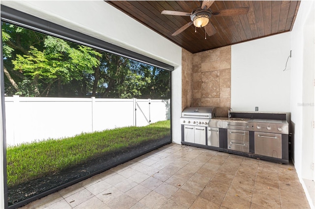 view of patio with a grill, ceiling fan, and an outdoor kitchen