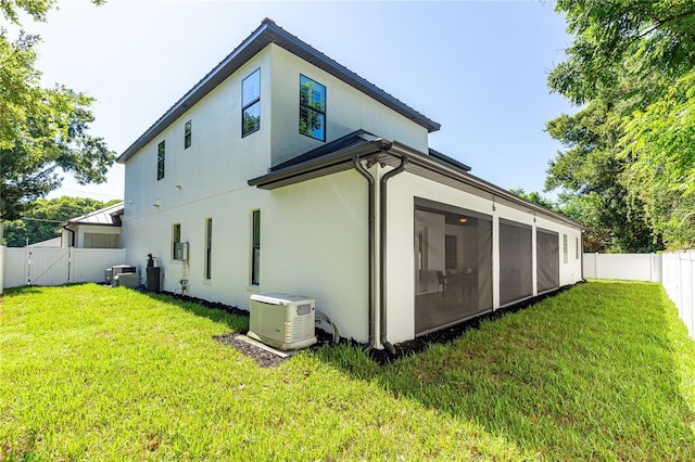 back of house with a yard and central air condition unit