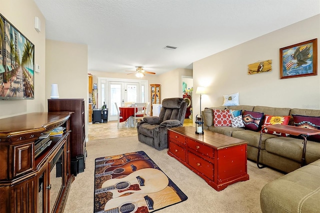 carpeted living room with french doors and ceiling fan