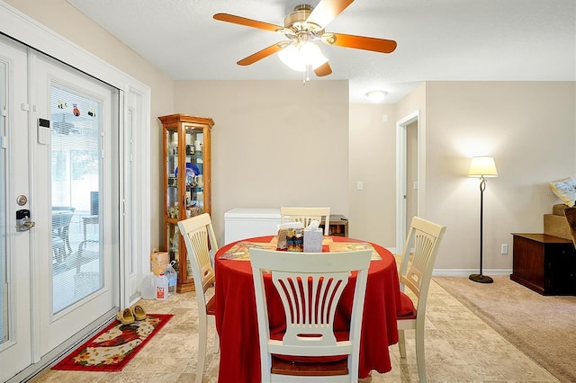 carpeted dining area with ceiling fan