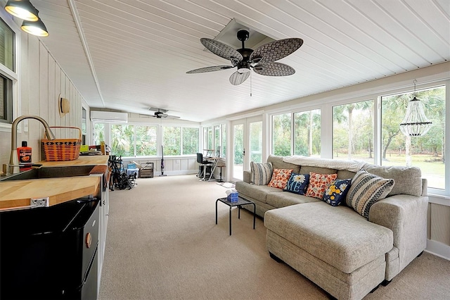 sunroom / solarium featuring an AC wall unit, ceiling fan, and sink