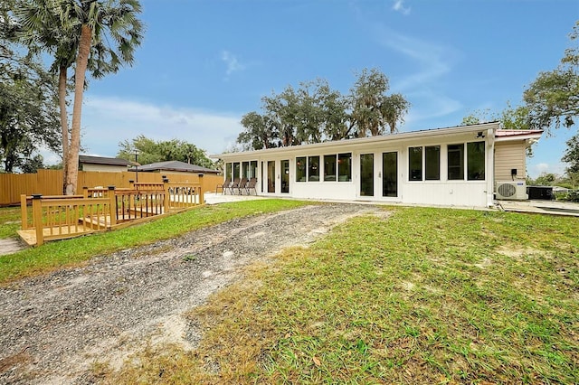 view of front of property with ac unit and a front yard