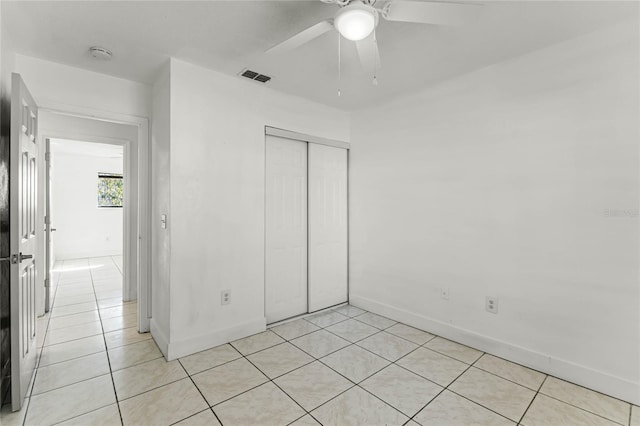 unfurnished bedroom featuring ceiling fan and a closet