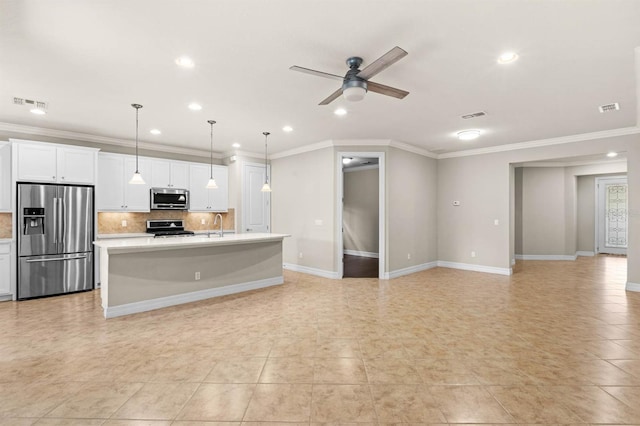 kitchen featuring ceiling fan, decorative light fixtures, a kitchen island with sink, white cabinets, and appliances with stainless steel finishes