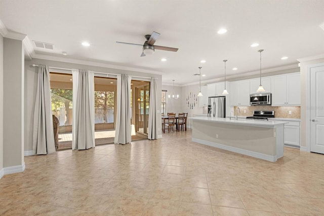 kitchen with pendant lighting, ceiling fan, an island with sink, appliances with stainless steel finishes, and white cabinetry